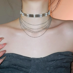 Vue détaillée d'un ras-du-cou en perles et chaînes argentées sur un mannequin féminin