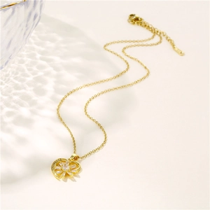 Collana con cuore e fiori in oro con zirconi in acciaio inox su sfondo beige