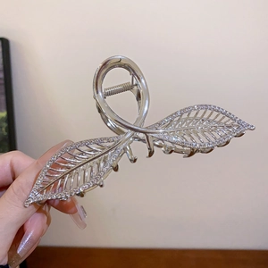 Gros plan détaillé d'une pince à cheveux argentée en forme de feuille avec diamants