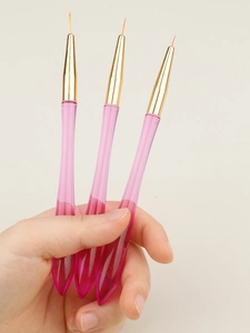 Close-up of three pink translucent nail liners held in hand for precision art