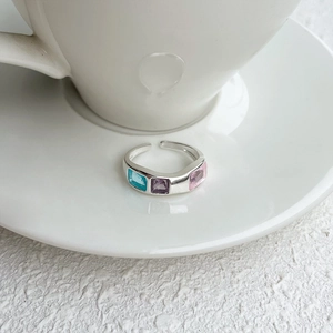 Detail of 925 silver open ring featuring three colorful rectangular gemstones in a cup