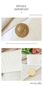 Detail of cream crocodile embossed leather with gold magnetic closure and fine stitching