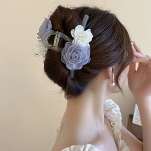 Dettaglio molletta per capelli con fiori di pizzo e perle su un'acconciatura elegante