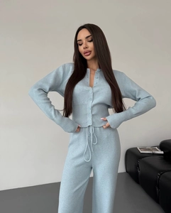 Detail of light blue knit set showing button-up cardigan and drawstring wide-leg pants