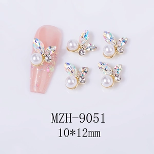Makroansicht von Schmetterlings-Nagelkunst-Charm mit Aurora-Strasssteinen und Perlen