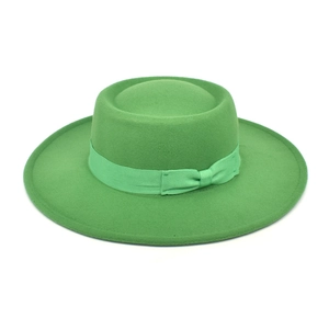 Detailed texture of grass green wool felt boater hat with a flat brim and silk ribbon