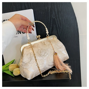 Detail of champagne gold floral embroidery on vintage shell bag with fringe and chain