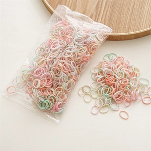 Macro detail of colorful pastel elastic hair bands for girls in packaging and loose pile