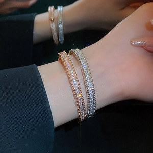 Close-up of luxury pave zircon bangles in rose gold and silver with beaded edges