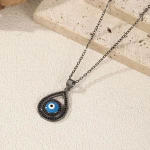 S925 silver blue devil eye pendant necklace with black stones on beige stone background