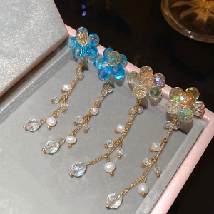 Macro view of blue and champagne flower tassel earrings with crystals and pearls