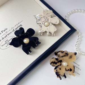 French pearl clover hair claws in black, marble beige, and tortoiseshell finishes
