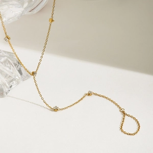 Detail view of gold stainless steel finger bracelet with shimmering zircon stones