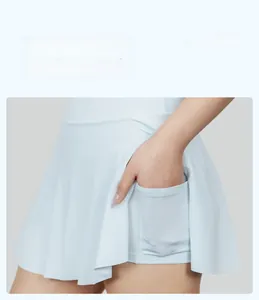 Detalle de falda deportiva plisada azul claro con pantalón corto y bolsillo para móvil