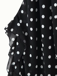 Detailed view of the ruffle edges and polka dot print on the lightweight chiffon dress