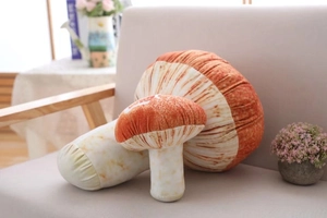Close-up of soft mushroom plush pillows in red and beige showing fabric texture