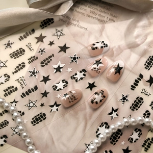 Y2K style nail stickers featuring black stars, checkerboard patterns and chain motifs