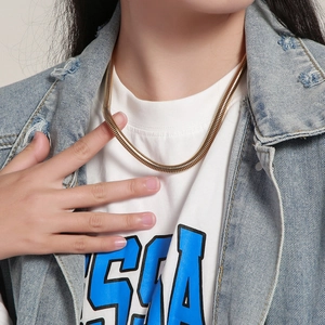 Golden stainless steel snake chain necklace shown on a model for length reference