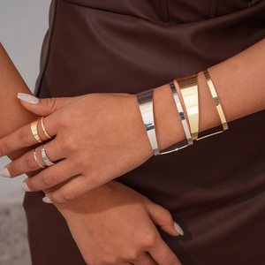Detail of minimalist irregular metal rings and cuffs set in polished gold and silver finish