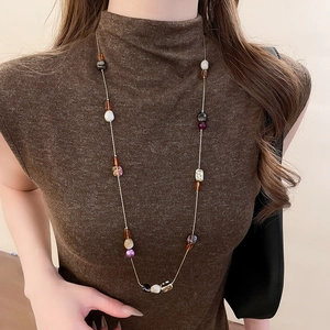 Collier rétro en perles d'oeil de tigre avec perles colorées sur pull marron