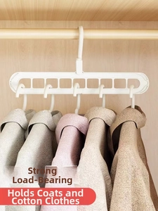 Detailed view of 9-hole magic clothes hanger saving space in closet with heavy coats