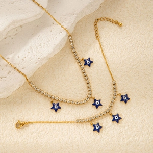 Macro detail of gold necklace featuring zircon crystals and blue evil eye star charms