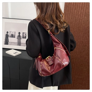 Detail view of burgundy vintage hobo bag with gold rivets and leather texture