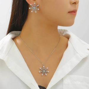 Detail of snowflake pendant necklace and earrings with crystals and small white pearls
