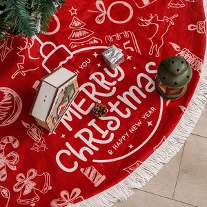 Red Christmas tree skirt with white tassels and festive Merry Christmas print on wood floor