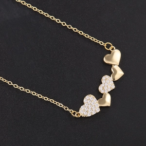 Exquisite gold heart necklace with sparkling zircon pavé and polished charms on black