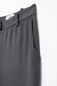 Detail view of deep gray dress pants showing waistband stitching and side pocket texture