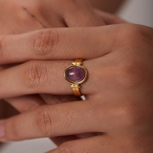 Anello vintage placcato oro 18K con gemma ovale viola indossato sulla mano