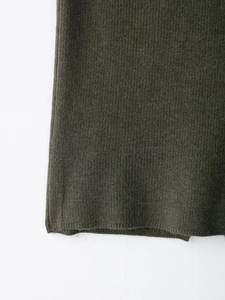 Vue macro détaillée de la texture en maille côtelée vert olive et de l'ourlet du vêtement