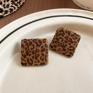 Macro view of square leopard print stud earrings with a soft flocked velvet texture