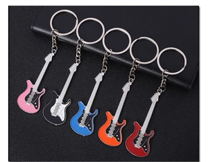 Macro shot of colorful enamel metal guitar keychains in pink, black, blue, and red