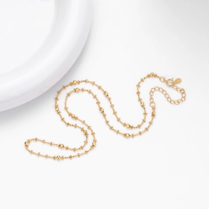 Detailed macro shot of S925 sterling silver gold beaded necklace with lobster clasp and chain