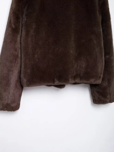 Detailed close-up of dark brown faux fur texture and soft fibers on short jacket