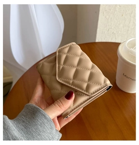 Close-up of a beige quilted leather folding wallet with precise diamond stitching texture