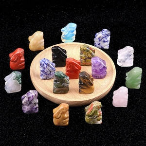 Group of 16 mini crystal rabbit figurines carved from natural gemstones on a wooden tray