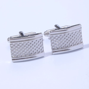 Close-up of classic silver square cufflinks with intricate cross-grid stripe texture