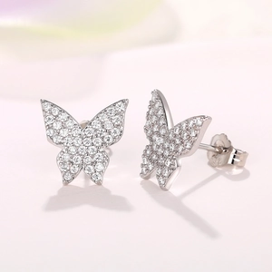 Macro shot of silver butterfly stud earrings with micro-pave cubic zirconia crystals