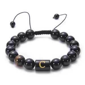 Detail of adjustable obsidian and tiger eye bead bracelet with engraved letter C