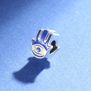 Macro view of blue enamel Hamsa hand charm with Evil Eye design in S925 silver