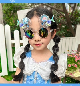 Girl wearing Elsa princess sunglasses with shell and mermaid tail details in the sun