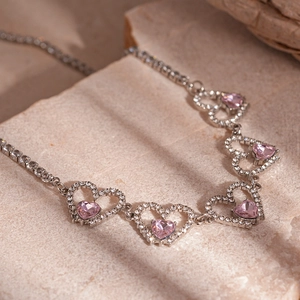 Detail of pink heart crystal necklace with tennis chain and white zircon pavé setting