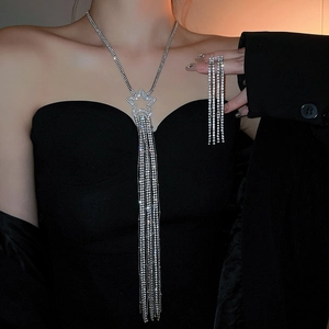 Dettaglio di collana con nappe argentate e orecchini a stella con strass su una modella
