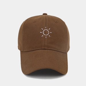 Detail of dark brown cotton baseball cap showing white sun embroidery and soft twill texture