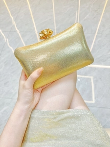Elegant gold rhinestone clutch bag for evening parties shown against a sequined dress