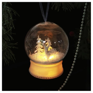 Close-up of lighted Christmas snow globe ornament with forest scene and warm LED glow