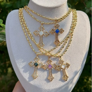 Vintage gold cross necklaces with colorful gemstones and pearls on display model
